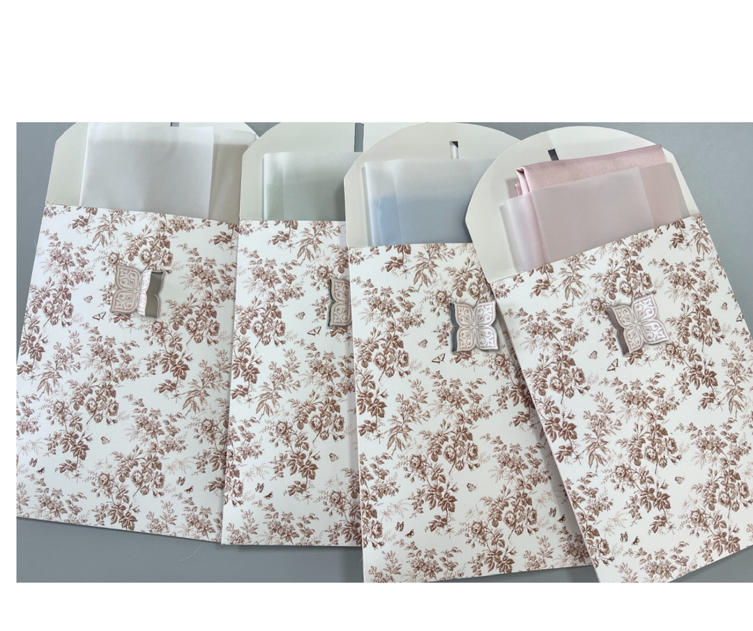 Mulberry silk pillowcases in elegant floral designer envelopes, showcasing soft pastel colors and premium packaging.