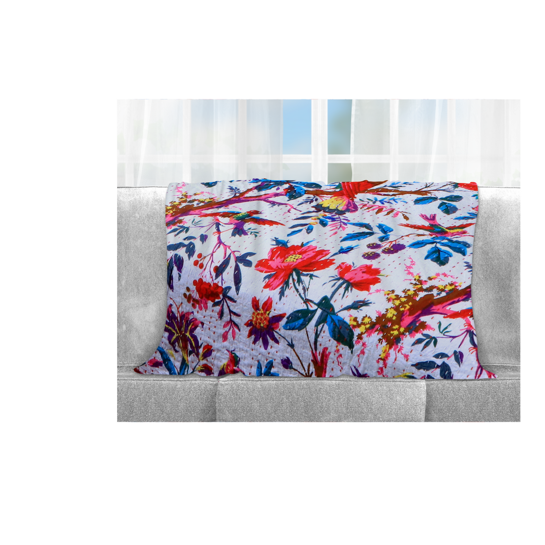 Kantha Blanket Bird of Paradise with vibrant floral and bird print, lightweight hand-stitched cotton quilt on sofa