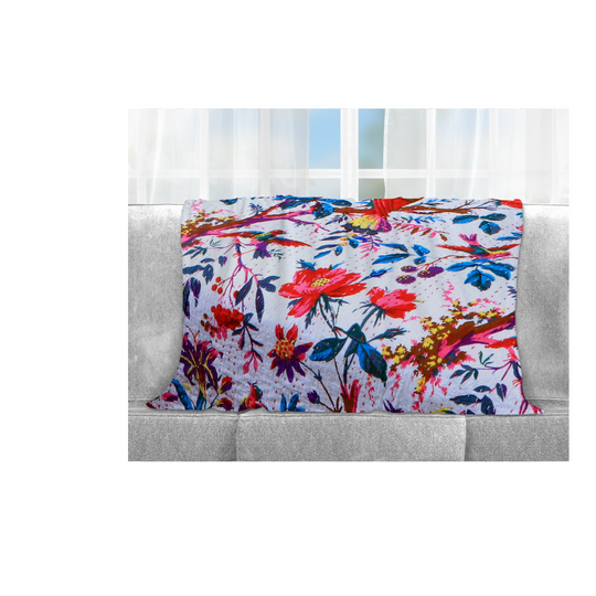 Kantha Blanket Bird of Paradise with vibrant floral and bird print, lightweight hand-stitched cotton quilt on sofa