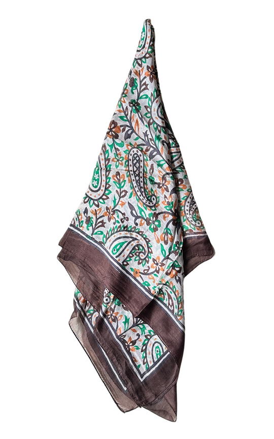 Lightweight hand-hemmed silk scarf with vibrant paisley and floral print in green, brown, and orange tones