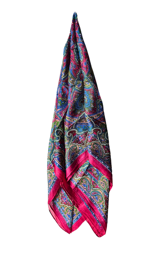 Hand-hemmed silk scarf with vibrant paisley pattern and pink border, lightweight and luxurious accessory.