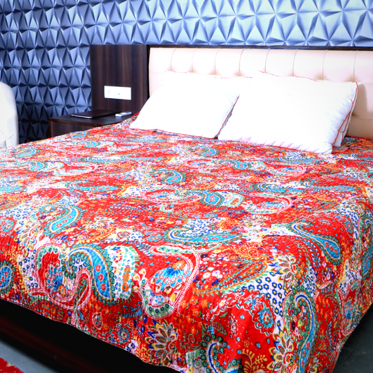 Bright red paisley Kantha blanket set with quilt and pillowcases on a bed in a modern bedroom