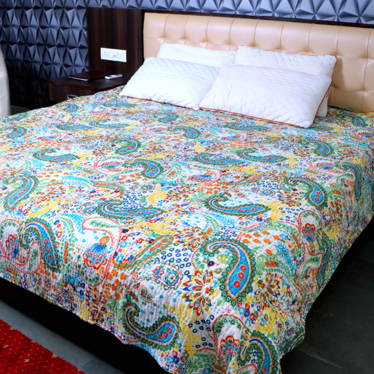 Kantha blanket set with colorful paisley pattern on bed with white pillows