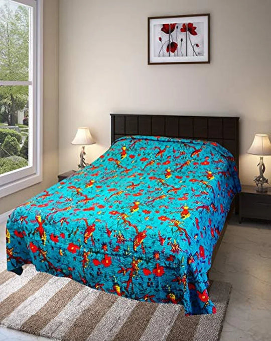 Bright blue Kantha blanket with bird and floral embroidery on bed in modern bedroom setting