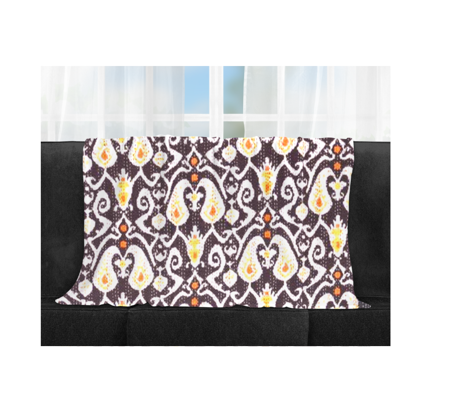 Kantha Blanket Ikat Design quilted lightweight cotton bedspread with traditional hand-stitched embroidery in black, white, orange, and yellow colors on sofa