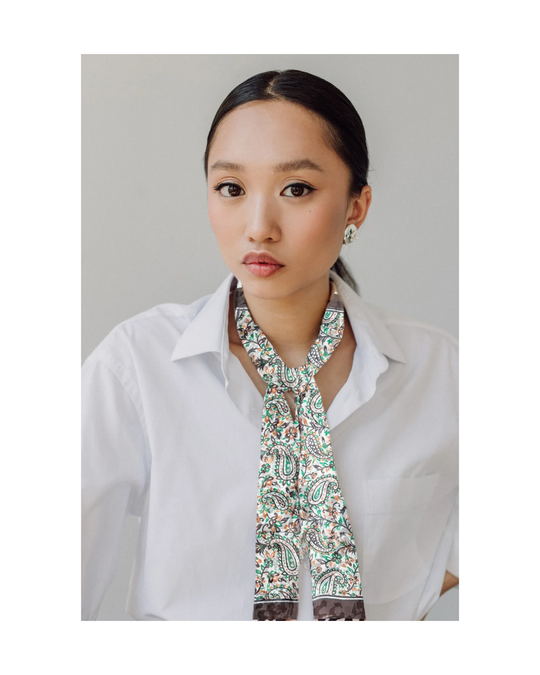 Hand-hemmed silk scarf in bright colors, worn by a person, showcasing its lightweight and luxurious texture.